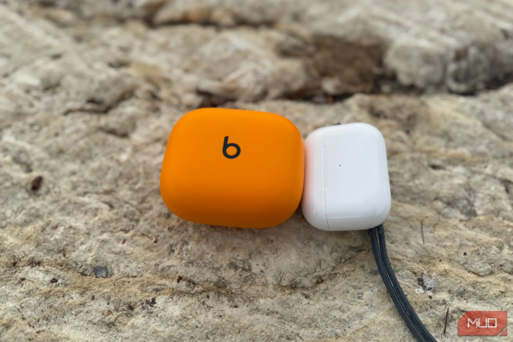 So sánh trực tiếp kích thước hộp sạc của AirPods Pro 2 và Powerbeats Pro 2, cho thấy sự khác biệt đáng kể về độ cồng kềnh.