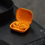 Tai nghe Powerbeats Pro 2 màu cam nổi bật với thiết kế móc tai, minh họa tính năng theo dõi nhịp tim.