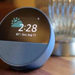 Thiết bị Amazon Echo Spot màu xanh đặt trên bề mặt gỗ, tượng trưng cho việc Alexa xử lý dữ liệu giọng nói trên đám mây