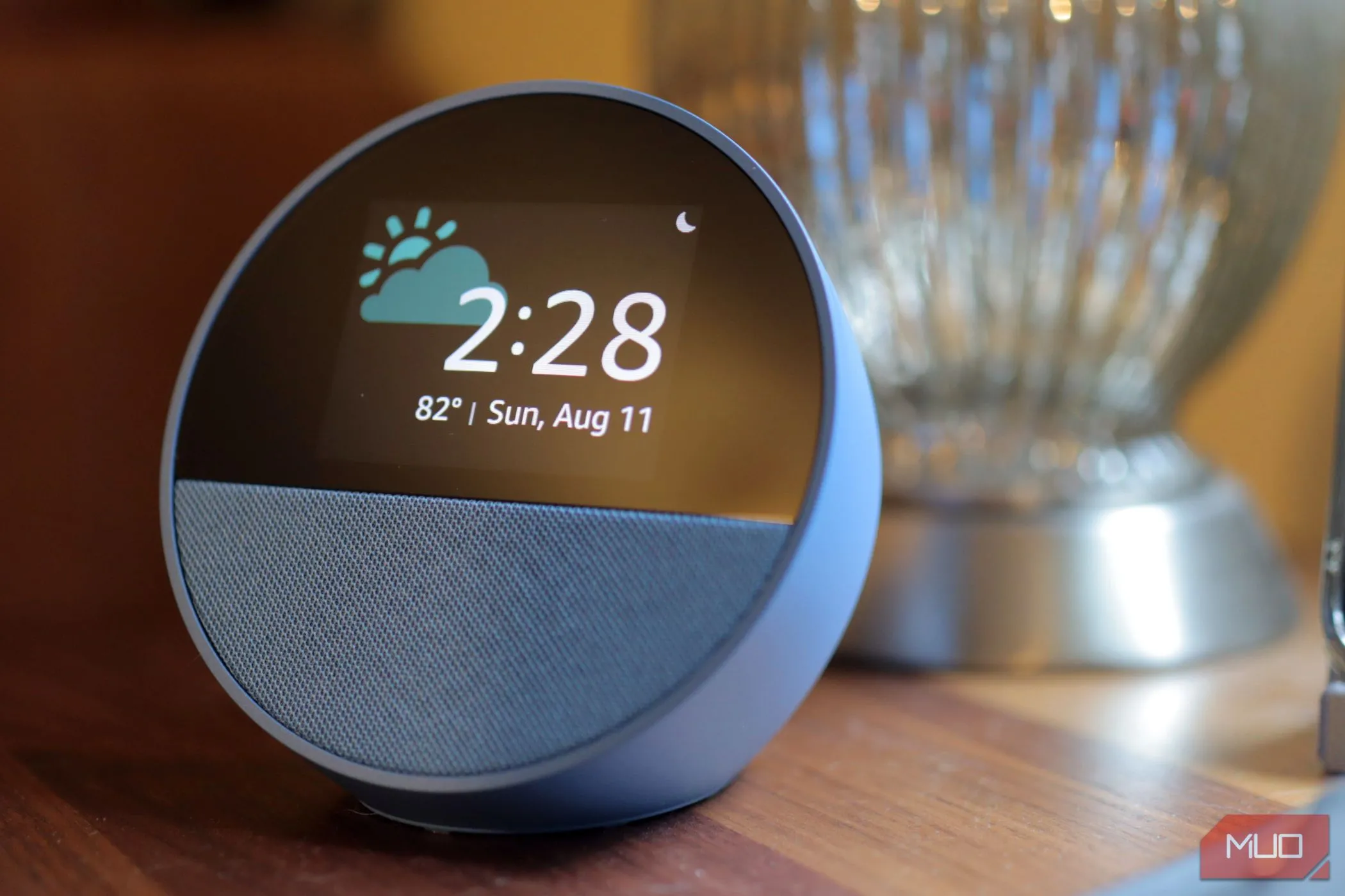 Thiết bị Amazon Echo Spot màu xanh đặt trên bề mặt gỗ, tượng trưng cho việc Alexa xử lý dữ liệu giọng nói trên đám mây
