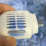 Thiết bị đuổi muỗi nhỏ gọn màu trắng, cấp nguồn qua cổng USB, lý tưởng cho những chuyến đi dài trên ô tô.
