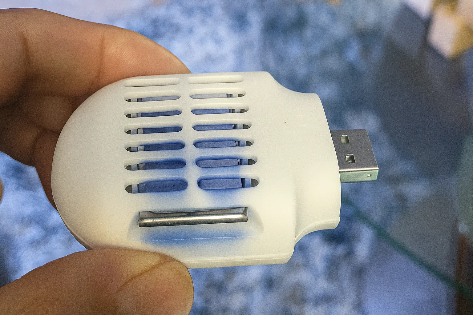 Thiết bị đuổi muỗi nhỏ gọn màu trắng, cấp nguồn qua cổng USB, lý tưởng cho những chuyến đi dài trên ô tô.