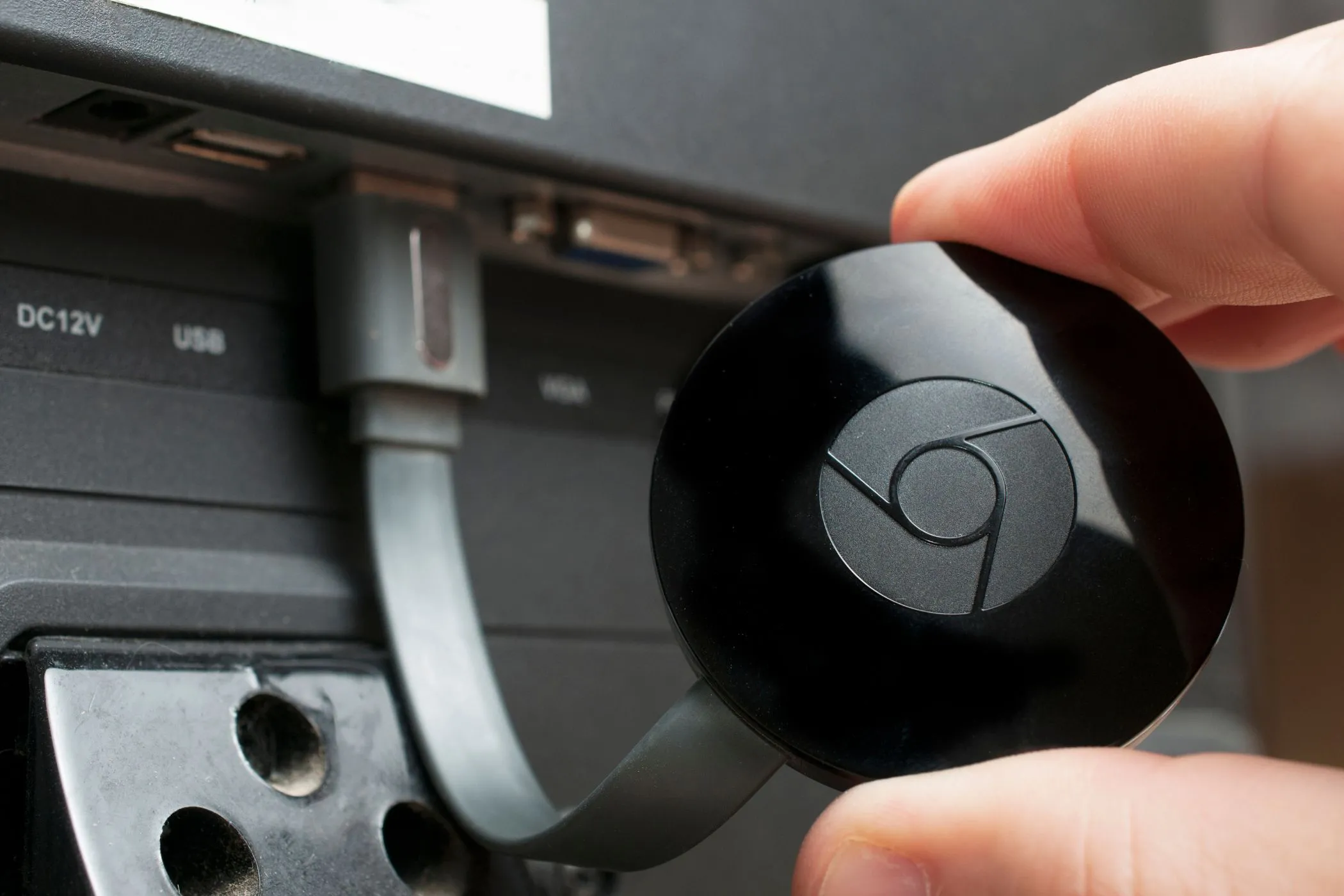 Thiết bị Google Chromecast đang cắm vào cổng HDMI của TV, minh họa cách chiếu nội dung từ iPhone