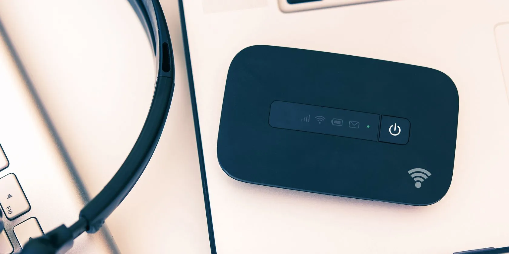 Thiết bị phát Wi-Fi di động (hotspot) đặt trên laptop, cung cấp kết nối internet ổn định và bảo mật cho việc làm việc từ xa.