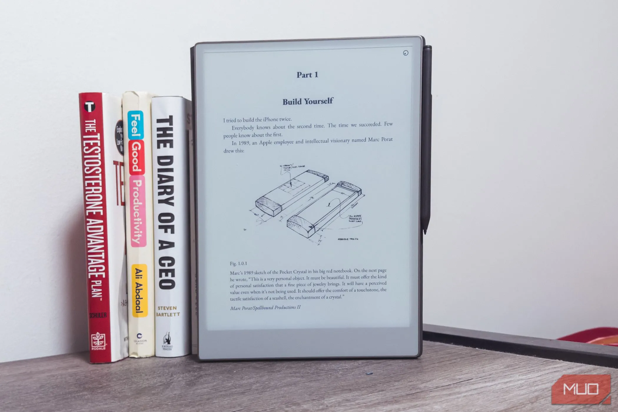 Thiết bị reMarkable Paper Pro đặt cạnh những cuốn sách trên bàn gỗ, làm nổi bật kích thước màn hình lớn