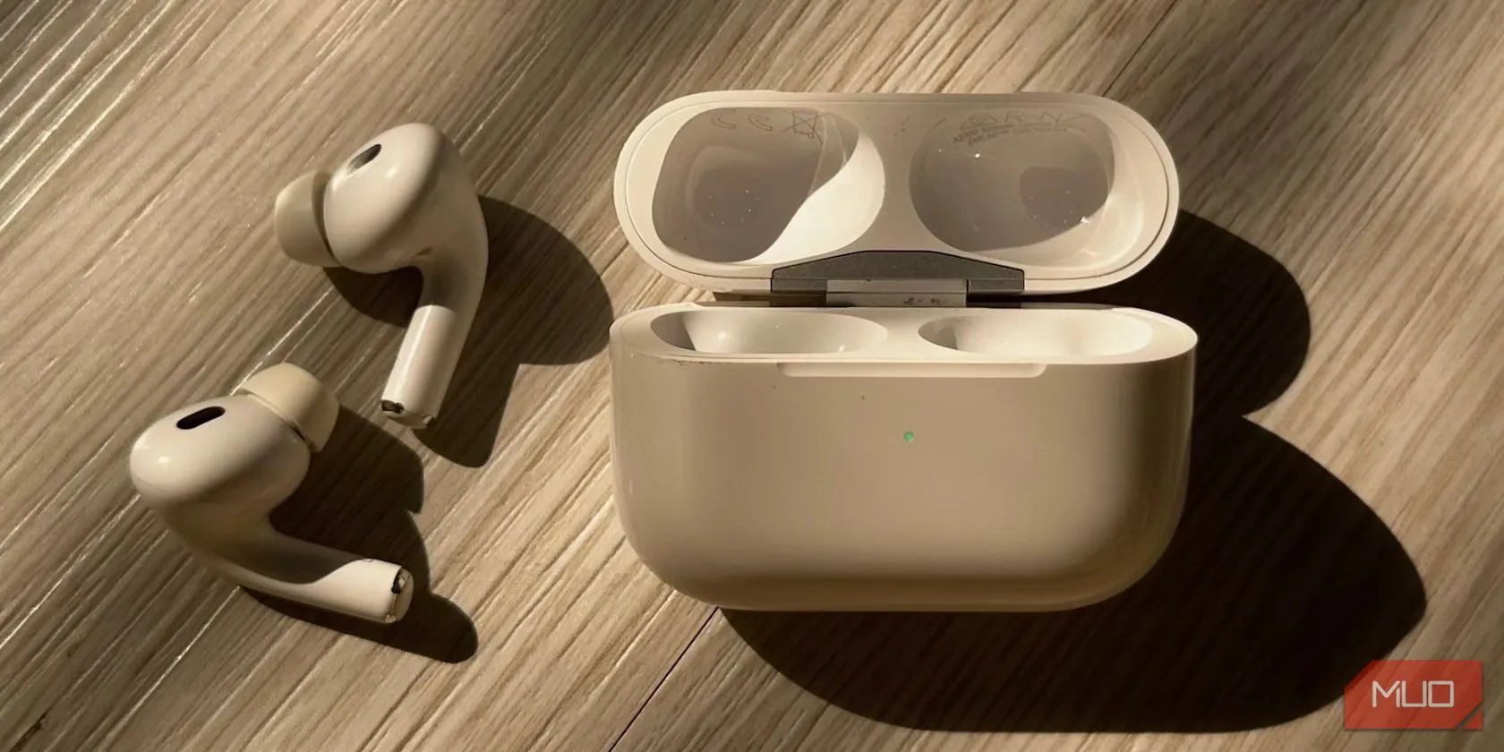 Vỏ sạc AirPods hiển thị đèn trạng thái màu xanh lá, thể hiện tình trạng sạc đầy hoặc đã kết nối