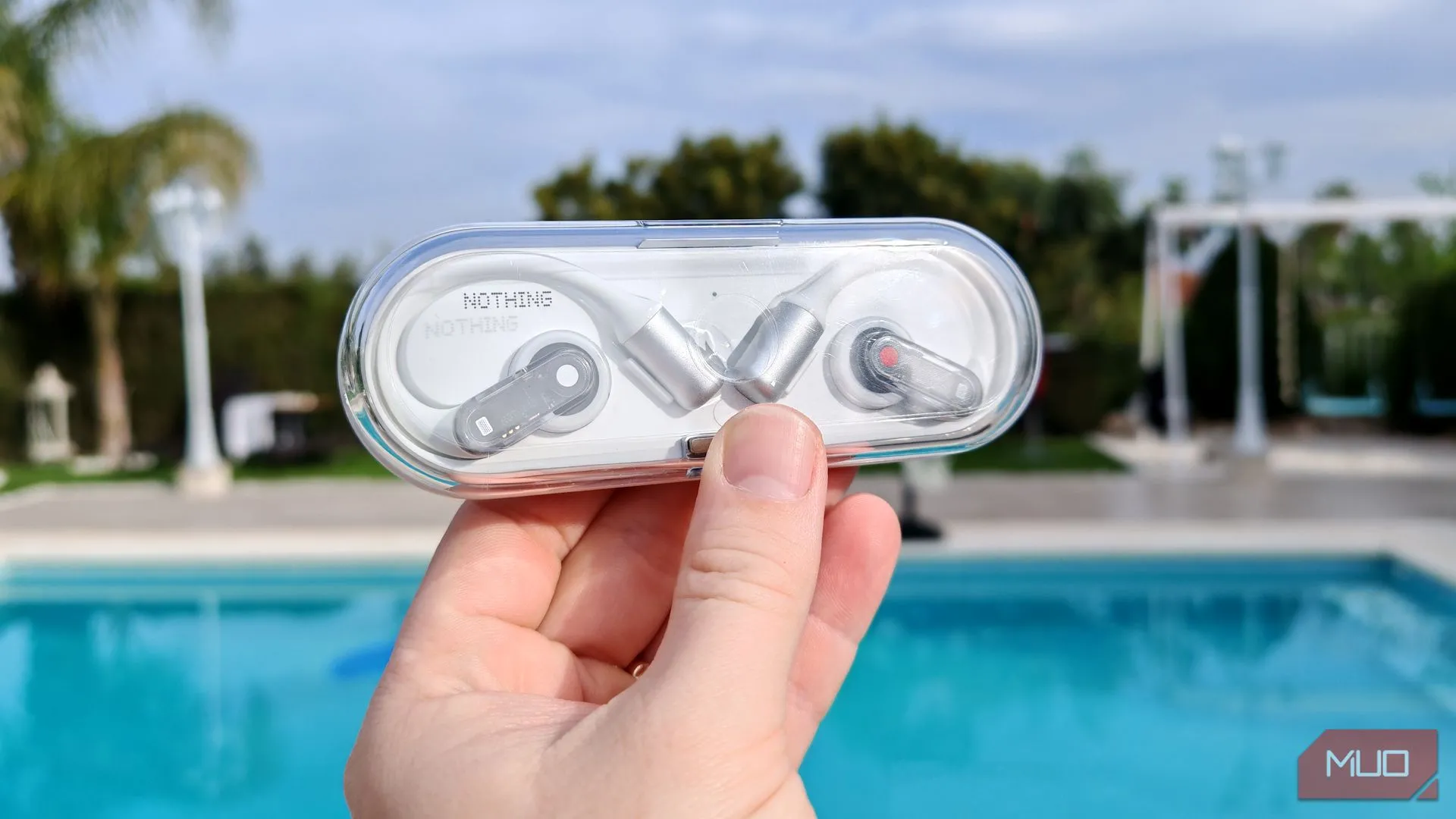 Vỏ sạc của Nothing Ear (open) được cầm trên tay ở ngoài trời